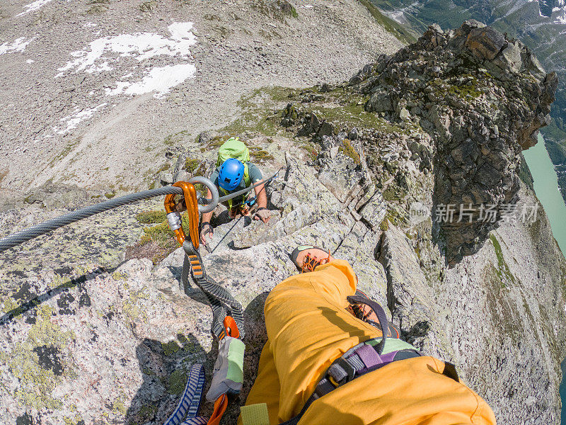 上图是攀登者伙伴的照片，一名男子正在攀登瑞士阿尔卑斯山的Via ferrata